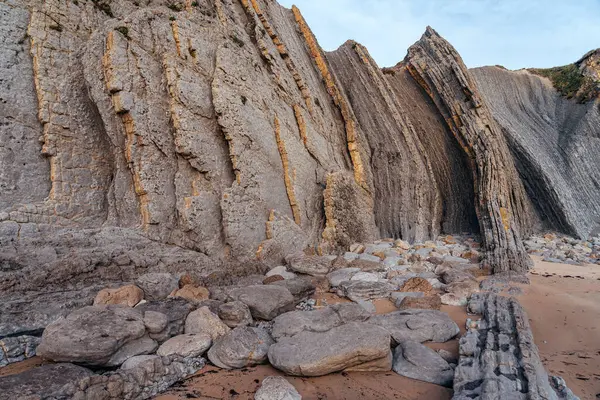 İspanya 'nın kuzeyinde Cantabria' da gün batımında Portio plajında renkli kaya oluşumları (Flysch).