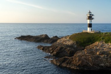 Pancha Adası deniz feneri, gün batımında Ribadeo sahilinde, Lugo vilayeti, Galiçya, İspanya