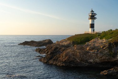 Pancha Adası deniz feneri, gün batımında Ribadeo sahilinde, Lugo vilayeti, Galiçya, İspanya