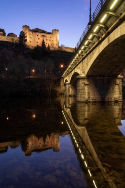 Puebla de Sanabria 'nın ortaçağ köyünün geceleri aydınlatıldığı kale ve köprü Tera Nehri, Zamora, Castilla y Leon, İspanya