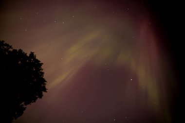 Bir jeomanyetik fırtına, Iowa üzerindeki gece gökyüzünde parlak yeşil ve pembe renklerle Aurora Borealis 'in oluşmasına neden olur.. 