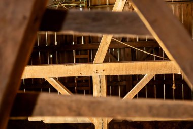 Eski bir ahırın içinde ahşap çivilerle tutturulmuş.