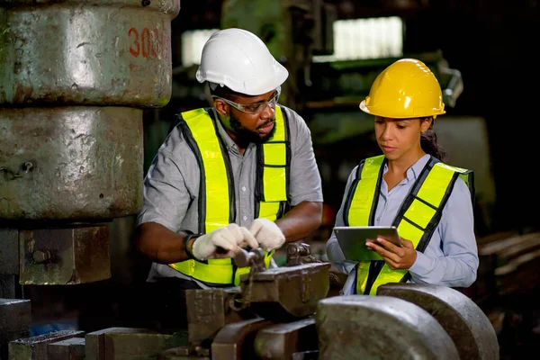 African American factory man discuss about machine function with his coworker woman and they also maintenance or repair process.