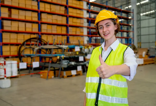 stock image Portrait of Caucasian warehouse factory worker woman show thumbs up to camera for concept of good environment and system support delivery and stock business.