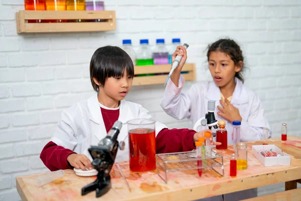 男孩和女孩在科学课上玩得很开心 在课堂上使用好几种类型的设备来获得更多的实验室工作技能 — 图库照片