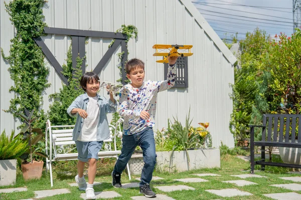 Dwóch Chłopców Wyglądają Zabawy Modelu Trzymać Samolot Uruchomić Domu Ogród — Zdjęcie stockowe