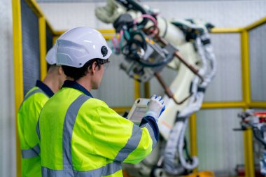 Profesyonel teknisyen veya mühendisin arkası ve arkası iş yerinde fabrika robotik kol makinesi ile çalışmak için denetleyici kullanın.