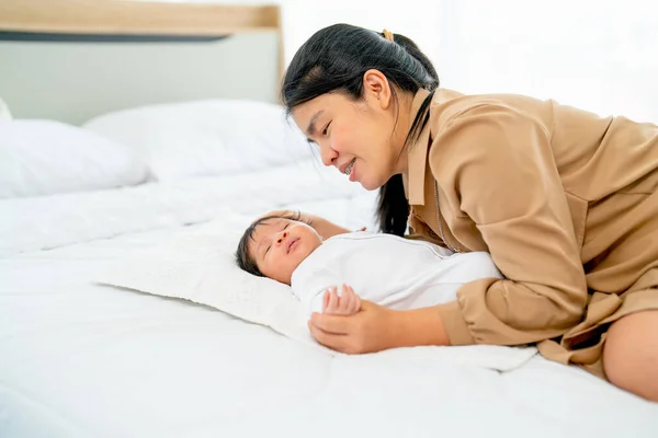 アジアの母親の横にある新生児のベッドの上でベッドの上で昼光と彼らはリラックスして幸せそうに見える — ストック写真