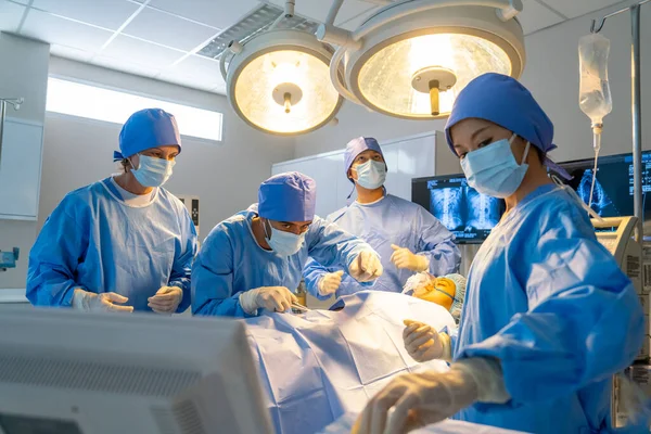 Doctor in operation room ask nurse to support tools for treatment in patient lie on bed and team staffs help to work for successful.