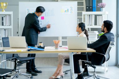 Asyalı işadamı, iş arkadaşı ve müdürün şirketteki kar verilerini gün ışığı ile birlikte gemide sunar..