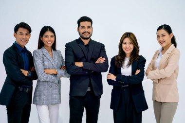 Kolları çapraz duran bir grup iş adamı ve kadın beyaz arka planda gülümseyen ve izole bir şekilde kameraya bakıyorlar..