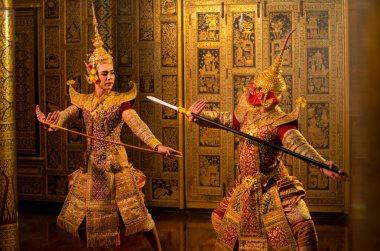Khon ya da geleneksel Tayland klasiği Ramakien dansından maskelenmiş insan ve kızıl dev tarafından Tayland tablolarının önünde halka açık alanda yapılan dövüş pozisyonu ile.