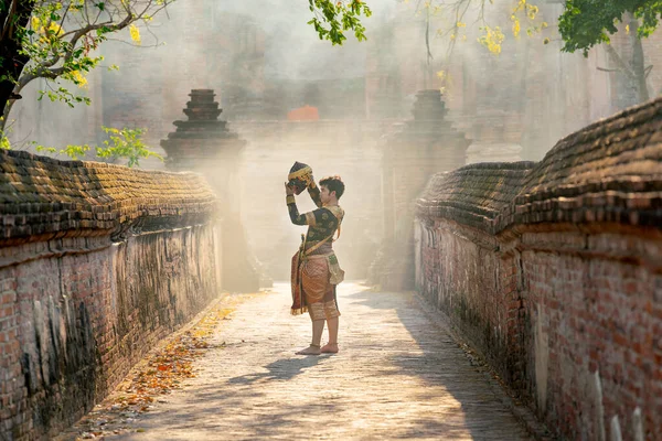 stock image Khon or traditional Thai classic masked from the Ramakien characters as black monkey dance in front of ancient building and stay on the way of old wall.