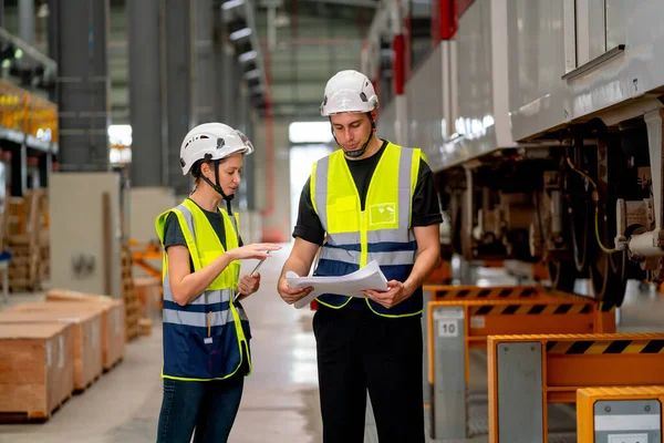 stock image Two professional engineer or technician worker discuss about work and stand near the train in workplace area.