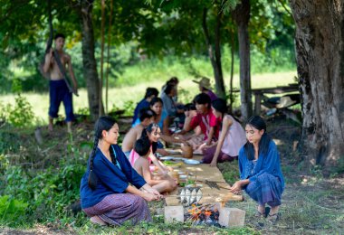 Bir grup Asyalı çiftçi ve genç çocuk pirinç tarlasında çiftçilik yapmak veya çalışmak için saban taşıyorlar ve etkinliklere birlikte katılmaktan mutlu görünüyorlar..
