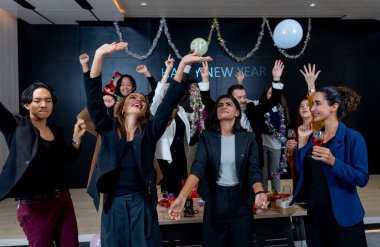 Çok ırklı bir grup iş adamı ve kadın, yeni yıl partisinde salonda dans etmekten zevk alırlar..