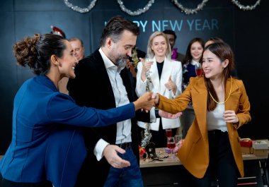 Asyalı iş kadını, şirketin yeni yıl partisinden hediyesini aldıktan sonra iş arkadaşına el sıkışır..