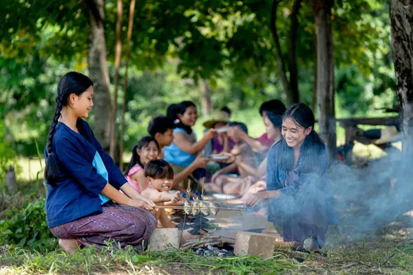 Asyalı iki kız pirinç tarlasında çiftçilik yaparken ya da tarlada çalışırken Asyalı çiftçilerin önünde ızgara balık pişirirse birlikte aktivitelere katılmaktan mutlu olurlar..
