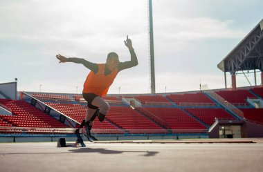 Sporcu sporcu protez bacakları, akşamın yumuşak ışıklarıyla stadyuma bakarak koşmaya başlıyor..