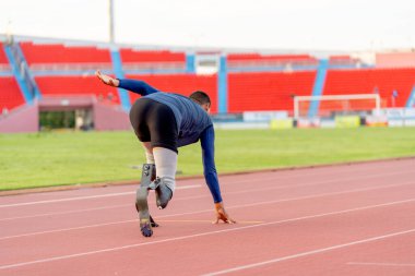 Sporcu atletlerin protez bacakları stadyumda gün ışığıyla koşuyor..