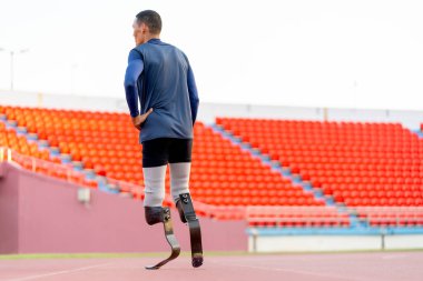 Sporcu atletlerin protez bacaklarının arkası gün ışığında stadyumun yolunda yürüyor..