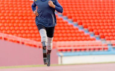 Spor adamı protez bacaklarının ön görüntüsü büyük yarışmadan önce antrenman yapmak için stadyumda koşuyor..