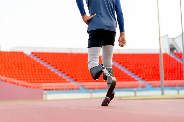 Close up athlete prosthesis legs of sport man in the back to walk up on track in the stadium with day light.