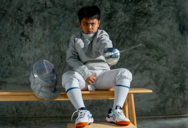 Eskrim formalı Asyalı çocuk idmandan sonra çişini tutup ön tarafını işaret ediyor..