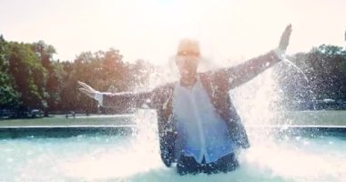 Sudaki genç adam çeşmede eğleniyor.