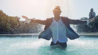 Sudaki genç adam çeşmede eğleniyor.