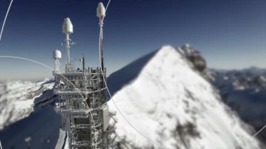 Yüksek karlı dağda duran radyo anten kulesinin havadan görüntüsü. Yüksek kalite 4k görüntü