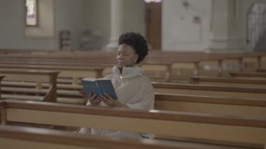 Kilisede dua eden kıvırcık saçlı genç Afrikalı kadın. Yüksek kalite 4k görüntü