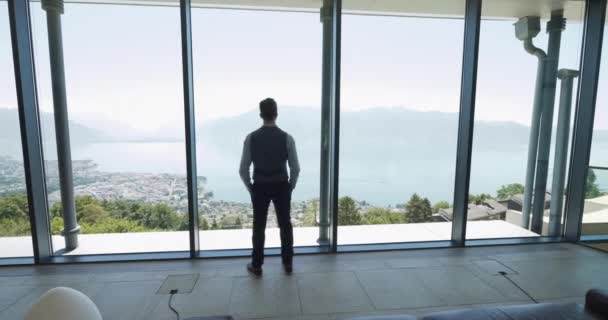 窓の眺めが付いている現代オフィス ビルの中の成功したヤング ビジネスマン 高品質の4K映像 — ストック動画