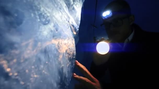 氷河の氷のトンネル洞窟の中を歩く男性エクスプローラー研究者 高品質の4K映像 — ストック動画
