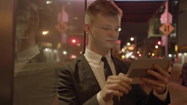 市内のタブレットスクリーンデバイスを使用する若いビジネスマン 高品質の4K映像 — ストック動画