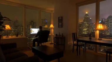 Skyline Manzaralı Yüksek Rise City Apartmanında Yaşayan Başarılı Genç Adam. Yüksek kalite 4k görüntü