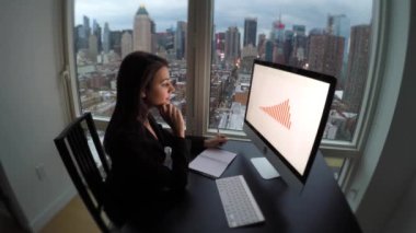 Modern Ofis 'te geceleri bilgisayar masasında çalışan kendine güvenen genç bir kadın. Yüksek kalite 4k görüntü