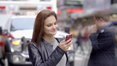 Şehirde akıllı telefon kullanan güzel beyaz bir kadın var. Yüksek kalite 4k görüntü