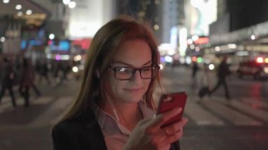 Şehirde akıllı telefon kullanan güzel beyaz bir kadın var. Yüksek kalite 4k görüntü