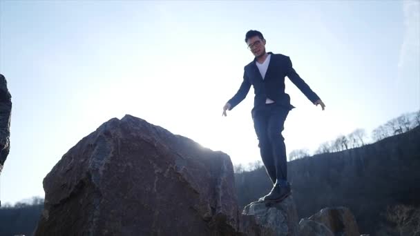石の岩の上を歩く男性は 障害を克服し 成功する 高品質の4K映像 — ストック動画