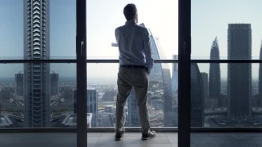 Genç Adam Şehir Binaları 'na bakarak yüksek katlı bir apartmanda başarılı oldu. Yüksek kalite 4k görüntü