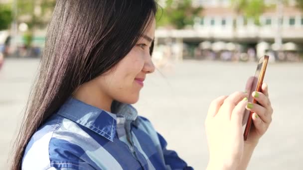 在城市街道上使用智能电话卡的年轻亚洲妇女 高质量的4K镜头 — 图库视频影像