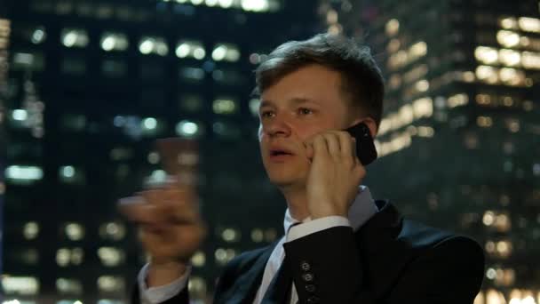 若いビジネスマンが市内の電話で話し チャット 高品質の4K映像 — ストック動画