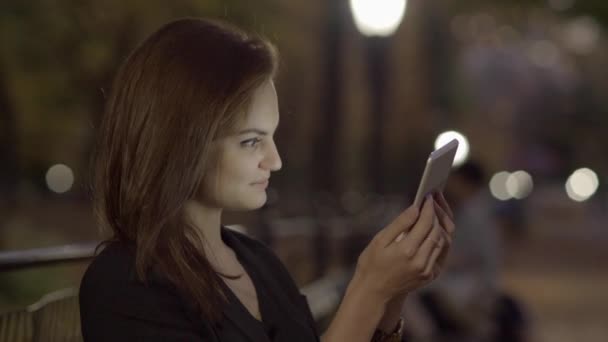Geceleri Parkta Tablet Bilgisayar Kullanan Genç Bir Kadın Yüksek Kalite — Stok video