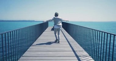 Retro Vintage Style Walking 'deki genç adam Lake View ile Bridge Road' da yürüyor. Yüksek kalite 4k görüntü