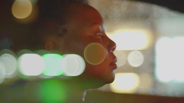 夜の交通ライトで都市で黒いカーリーヘアの運転車を持つ女性の人 高品質の4K映像 — ストック動画