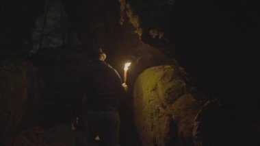 Karanlık Gece 'de Yanan Meşale Işığı Tutan Adam Orman Mağarası' nı Keşfediyor. Yüksek kalite 4k görüntü