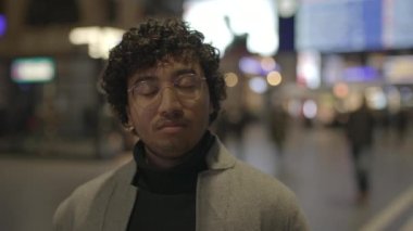 Tren istasyonunda siyah kıvırcık saçlı genç adamın yaşam tarzı portresi. Yüksek kalite 4k görüntü