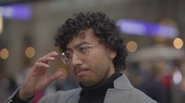 Tren istasyonunda siyah kıvırcık saçlı genç adamın yaşam tarzı portresi. Yüksek kalite 4k görüntü