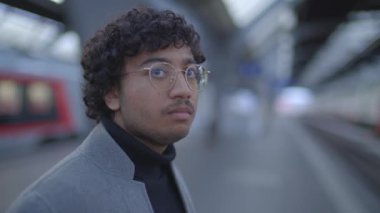 Tren istasyonunda siyah kıvırcık saçlı genç adamın yaşam tarzı portresi. Yüksek kalite 4k görüntü